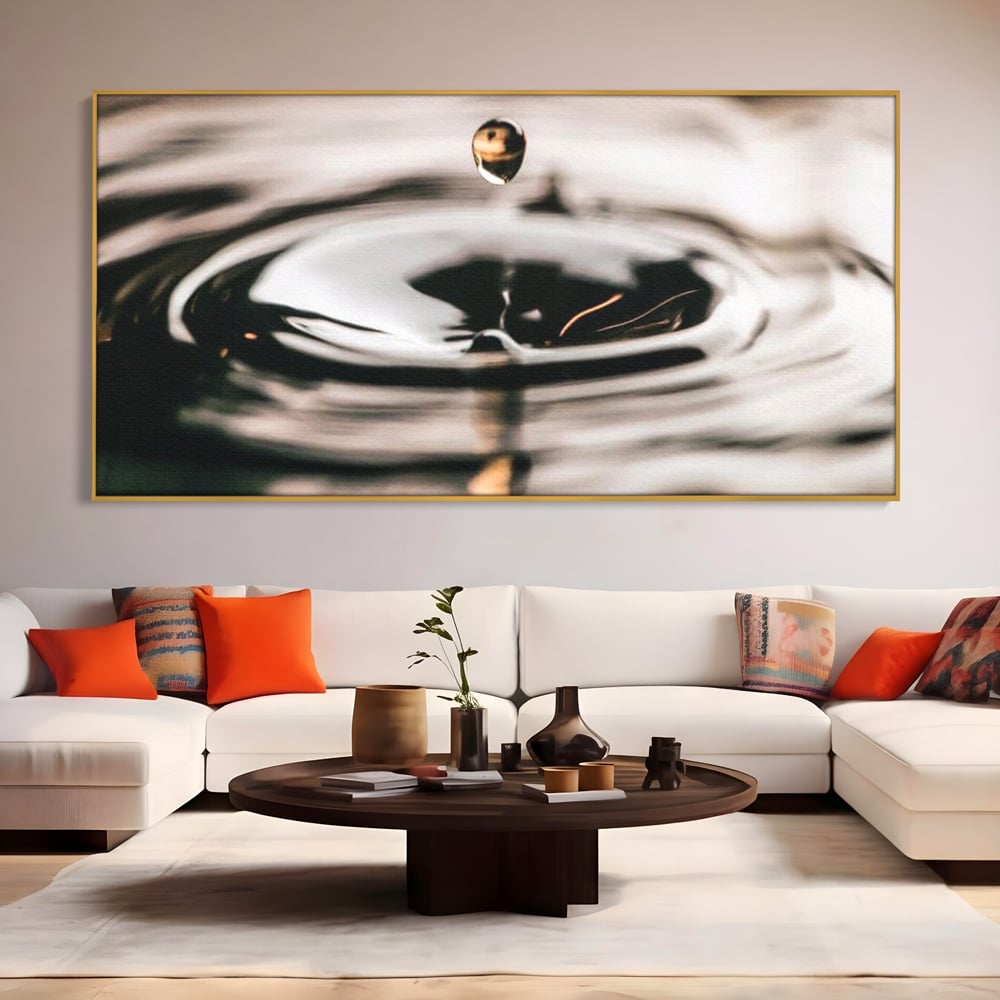Tablou canvas cu picatura de apa cazand in valuri, in rama de aluminiu auriu, pe perete intr-un living